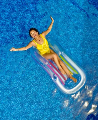 Woman Floating On A Floating Raft In A Pool